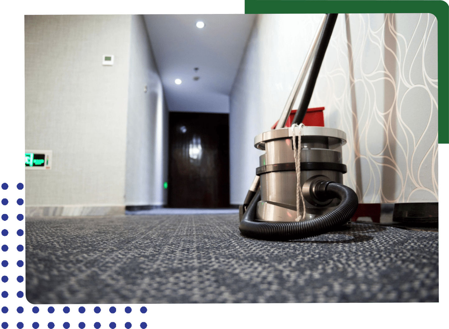 A vacuum cleaner is sitting on the floor in front of a hallway.