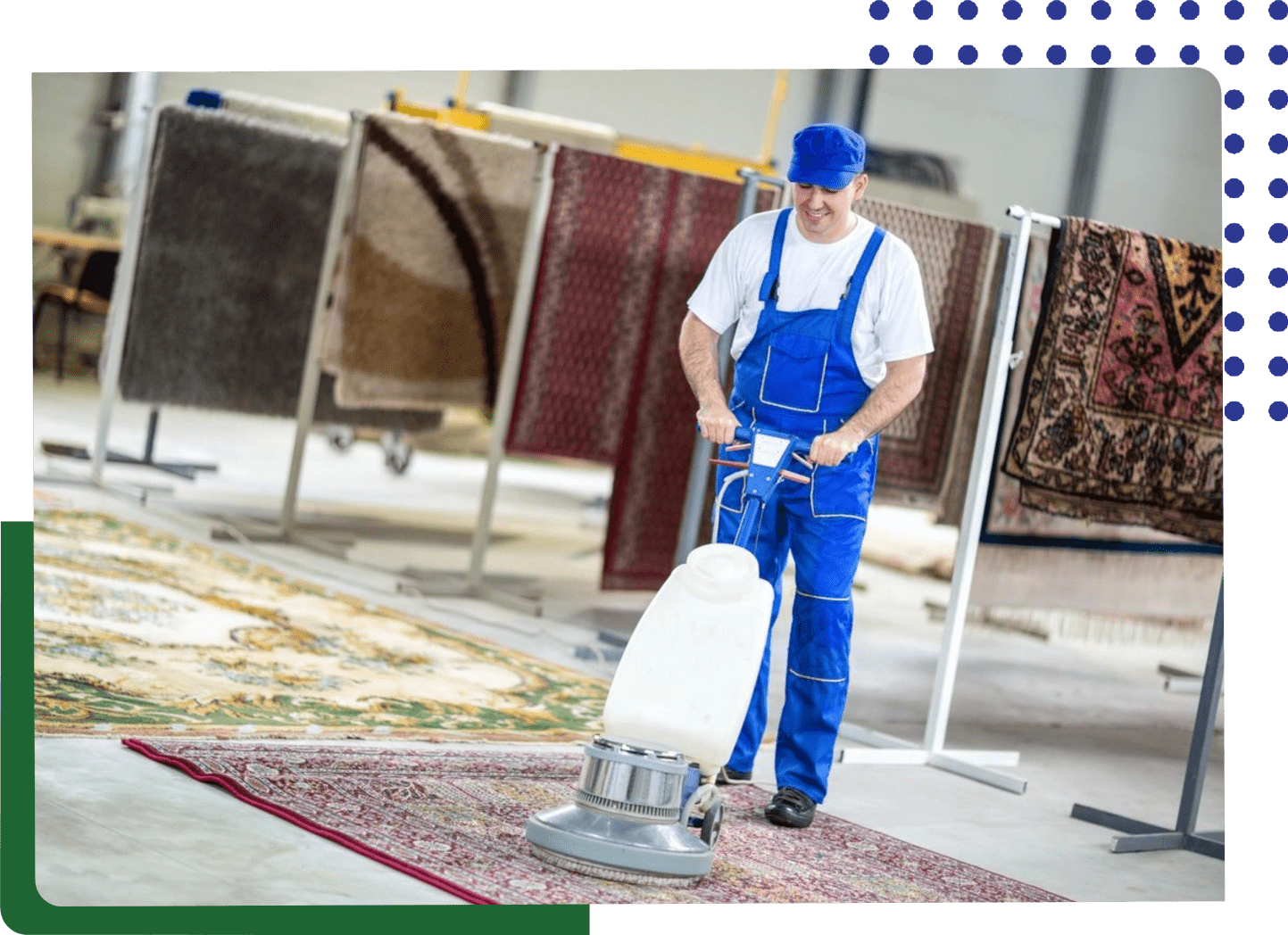 A man in blue overalls is vacuuming the floor.