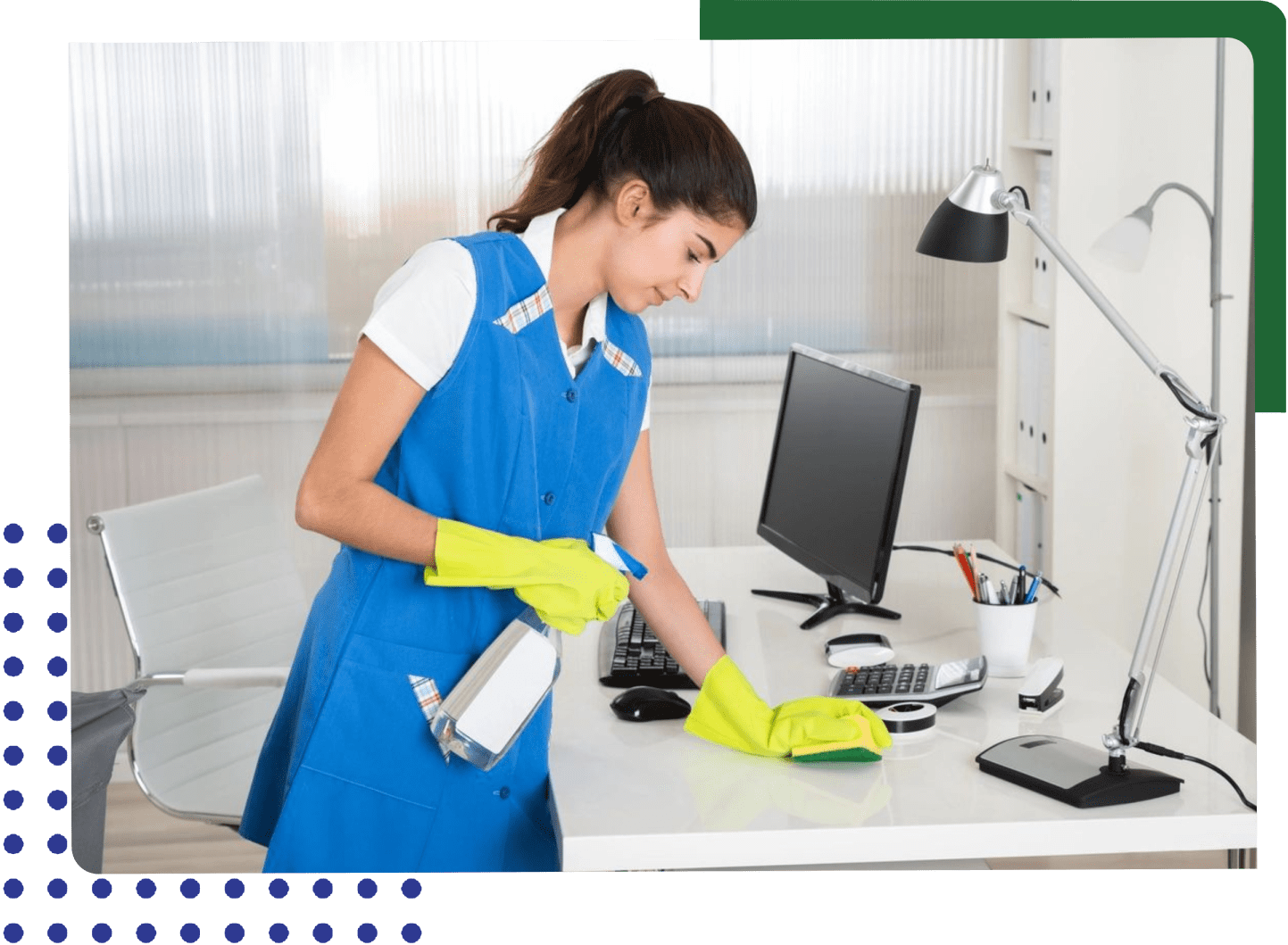 A woman in blue shirt and yellow gloves cleaning desk.