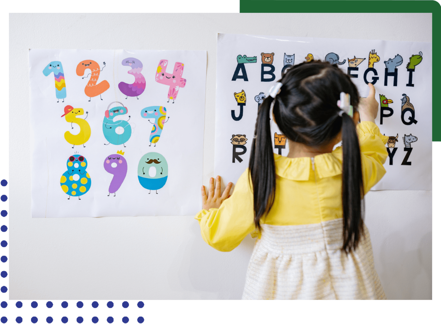 A little girl is playing with numbers on the wall.